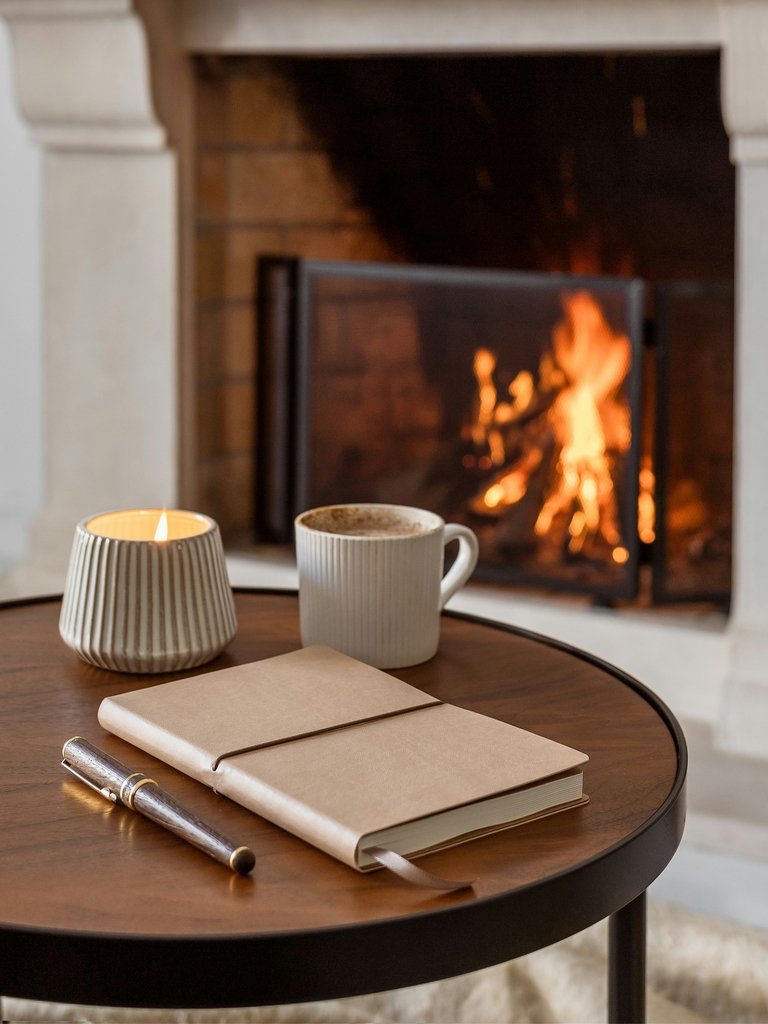 A beautiful setting in a warm, cosy atmosphere with fireplace, a jornal and a coffee mug.