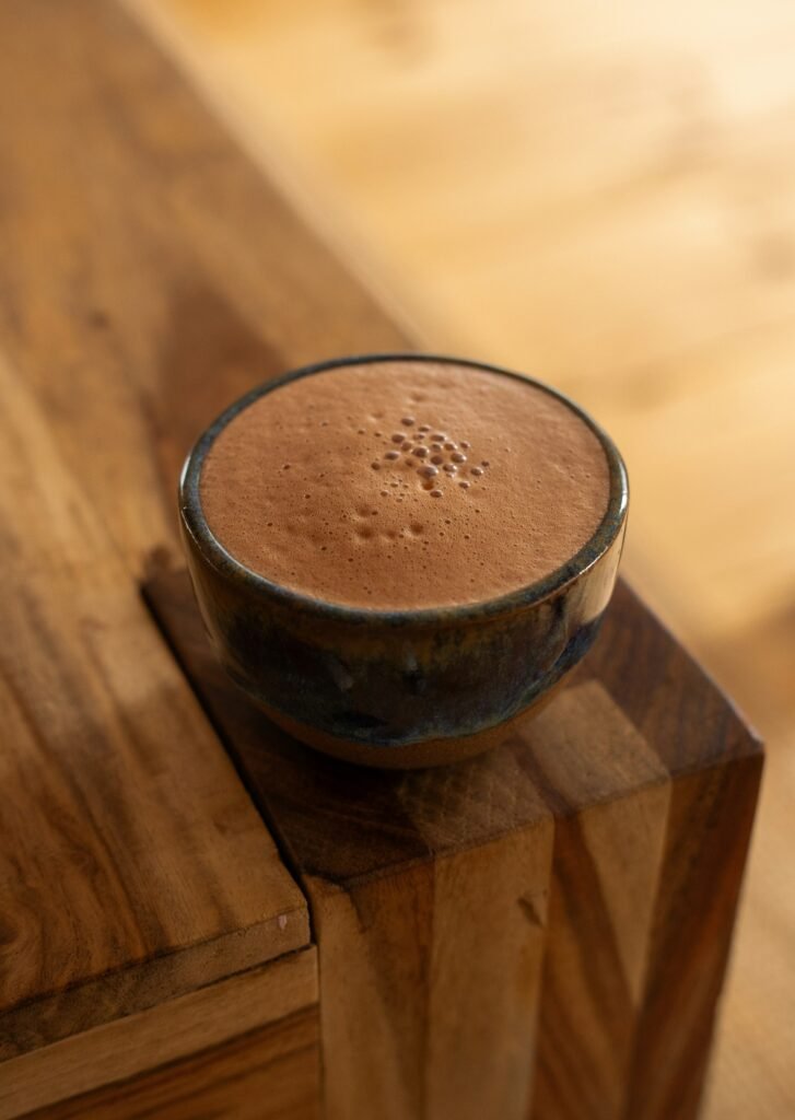Cup of ceremonial grade cacao on a wooden table